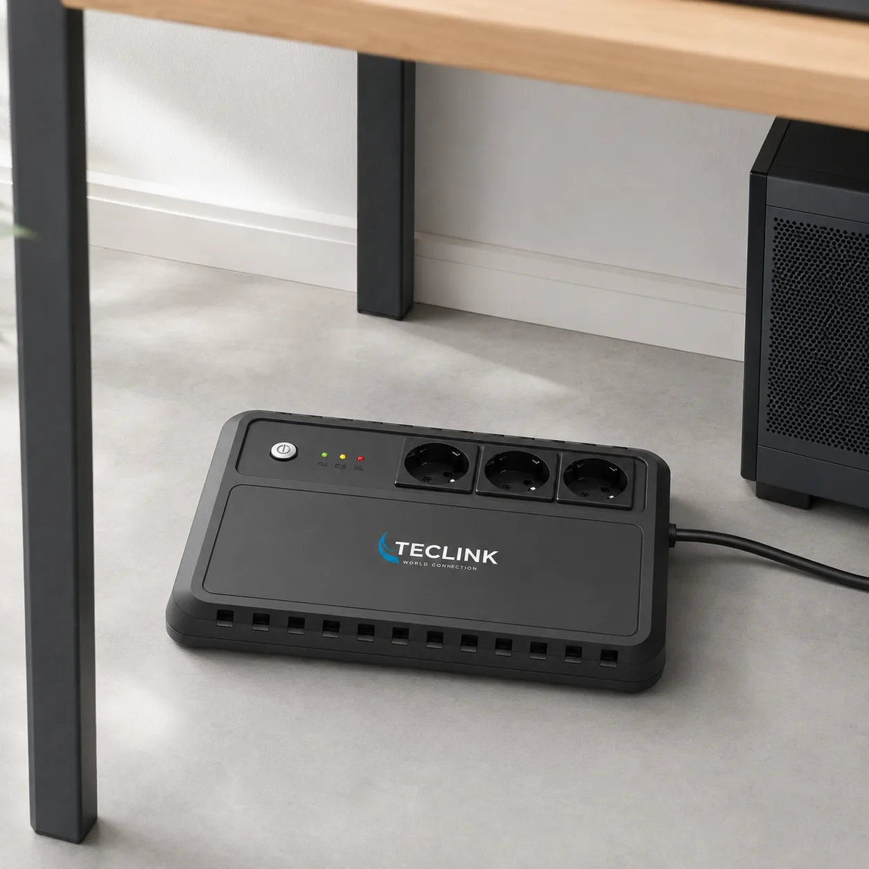 Onduleur compact TECLINK TLOD1650 posé à plat sous un bureau sur un sol dur et ventilé